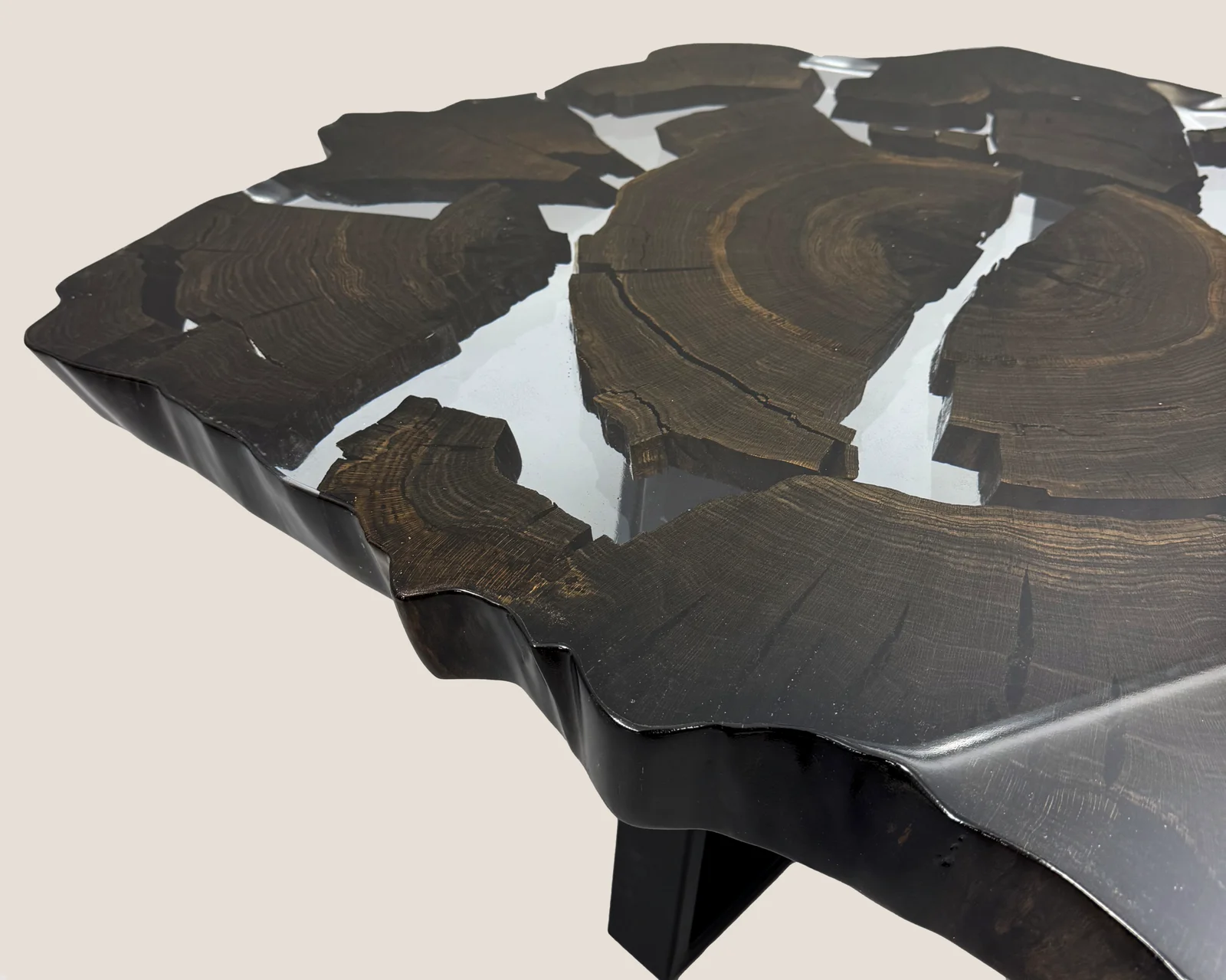 Tisch aus dunklem Massivholz mit hellem Resin auf filigranem Stahlgestell